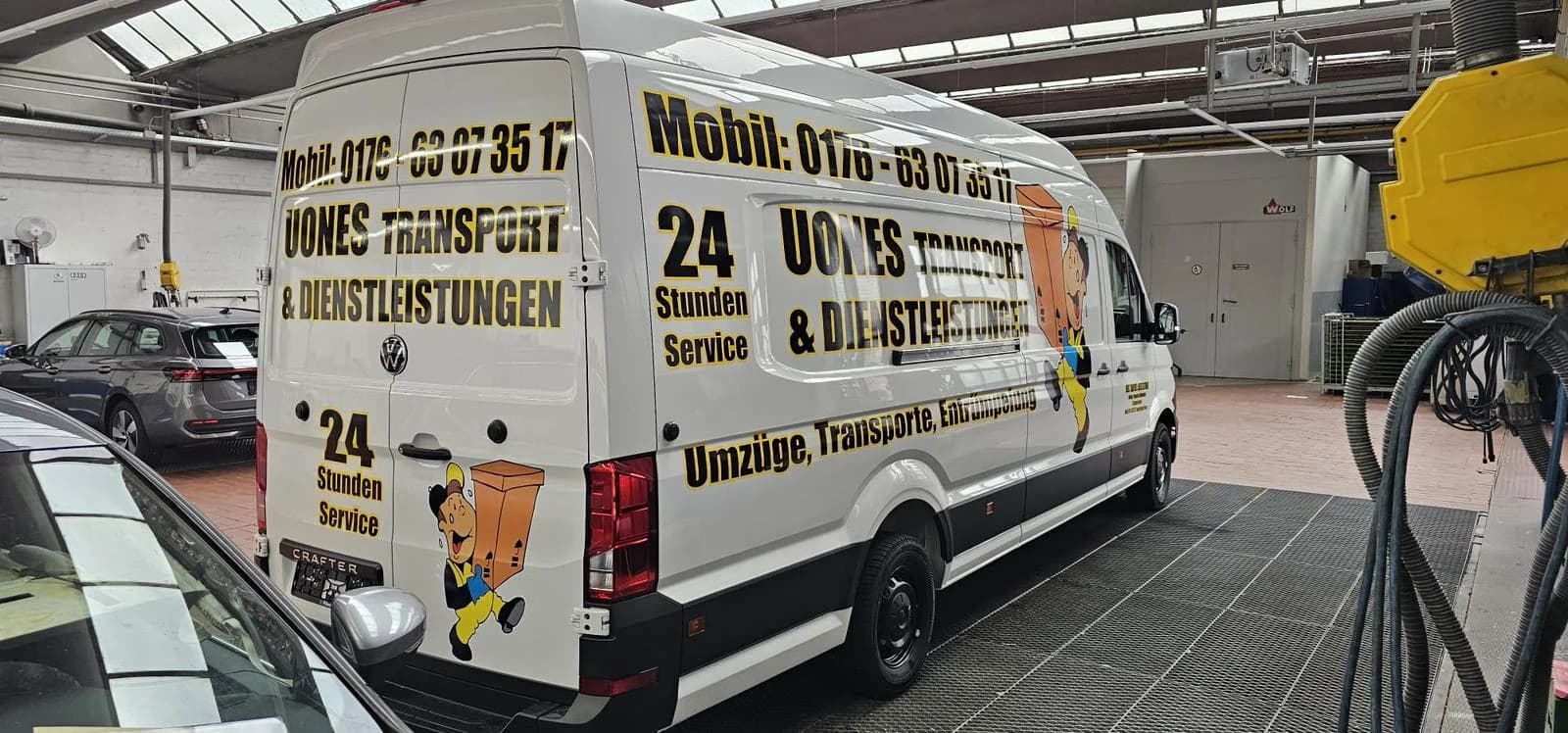 Heckansicht eines UONES-Transporters mit Packer-Motiv und Beschriftung an Seite und Hecktür