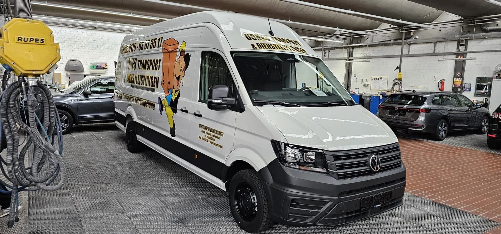 Großraumtransporter von UONES mit Packer-Beschriftung, Ansicht schräg von vorne in einer Halle
